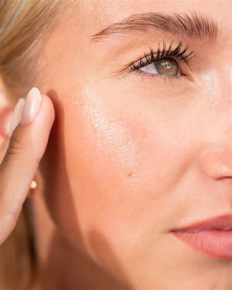 Obrázok ženy aplikujúcej arganový olej na tvár.