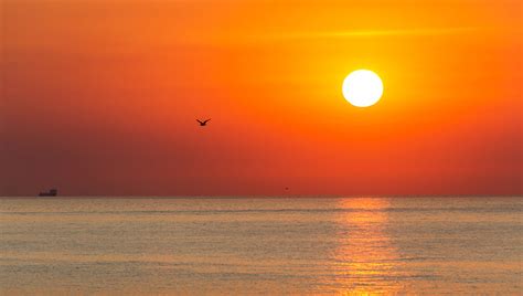 žena s psoriázou na pláži, ktorá si užíva slnko pri mori