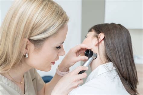 Dermatológ vykonáva dermatoskopické vyšetrenie znamienka pomocou zväčšovacej lupy.