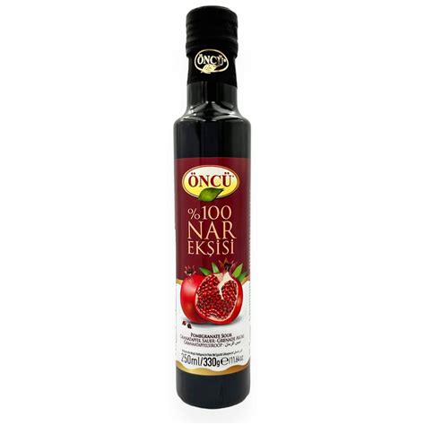 fľaša oleja z granátového jablka s kvapkadlom na pozadí zrelých plodov granátového jablka