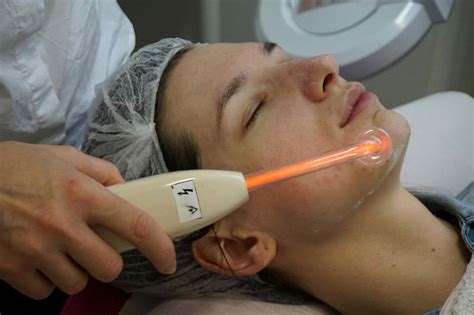 Dizajnérska predstava: Ozonizér v akcii - kozmetička aplikuje sklenenú elektródu na pleť klienta.