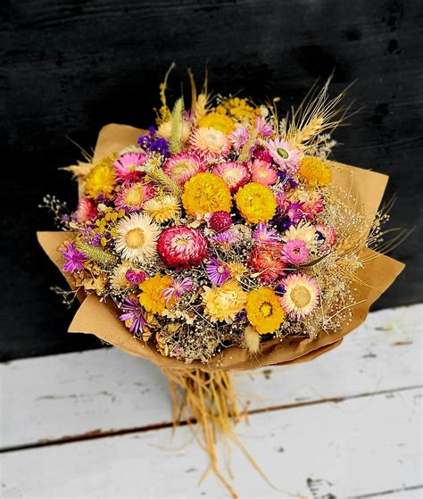 Fľaštička s arganovým olejom vedľa sušených kvetov argánie