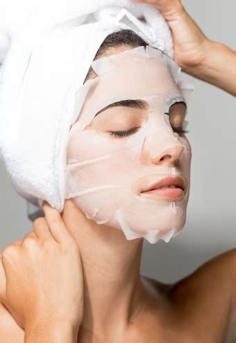Ilustračná fotografia ženy s čistou, zmatnenou pleťou, ktorá si aplikuje pleťovú masku.