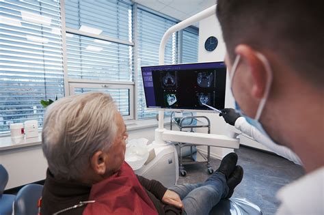 Lekár vykonáva vizuálnu prehliadku ústnej dutiny pacienta.