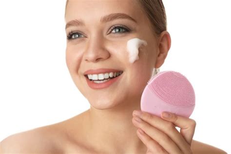 Ilustračné foto mladej ženy používajúcej elektrickú čistiace kefku na tvár