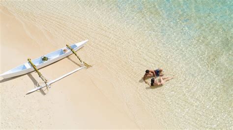 Rodina (deti aj dospelí) na pláži, spokojne si užívajú slnko, s jemným naznačením ochrany pred slnkom