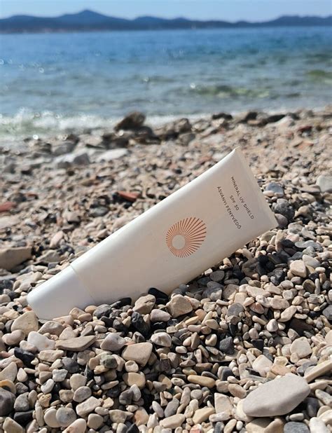 Fotografia ženy aplikujúcej SPF krém na tvár