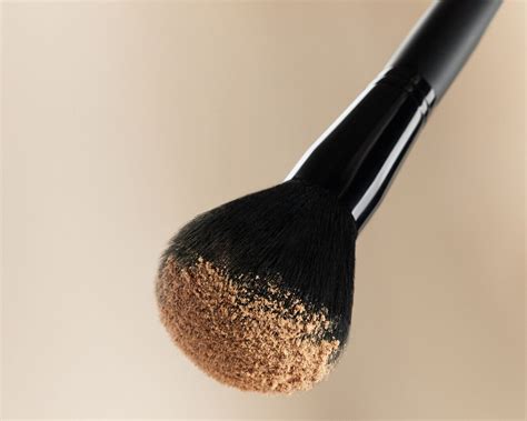 Tematická fotografia sypkého púdru a štetcov na make-up