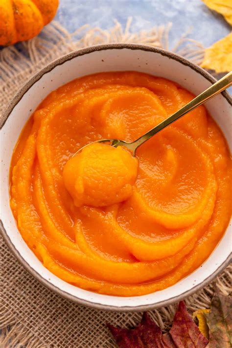 Thematic photo of a carved pumpkin next to skincare ingredients like honey, eggs, and a small bowl of pumpkin puree