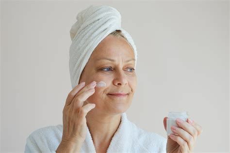 Žena si natiera tvár krémom Dixi Visage, s mandľami v pozadí