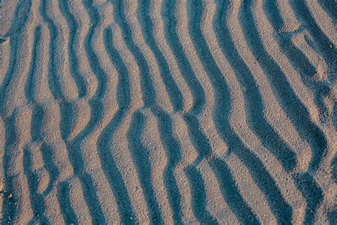 Detailný záber čierneho piesku s viditeľnými zrnkami monazitu